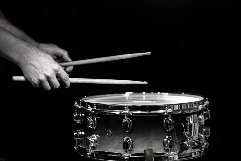 How to Hold Drum Sticks - intro image- someone holding drumsticks greyscale image.